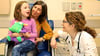 Pediatric allergist Christina Ciaccio, MD, consults with a patient and her mom as she tries her first taste of peanut candy